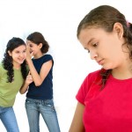 two young girls laughing behind another girls back. Photo by zalouk webdesign