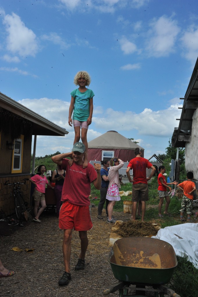 泰德和他的女兒，背景是我們正在用泥巴和稻草建牆壁。Emma提供